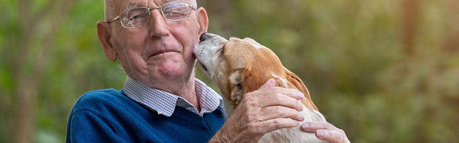 elderly-man-being-kissed-on-cheek-by-small-dog